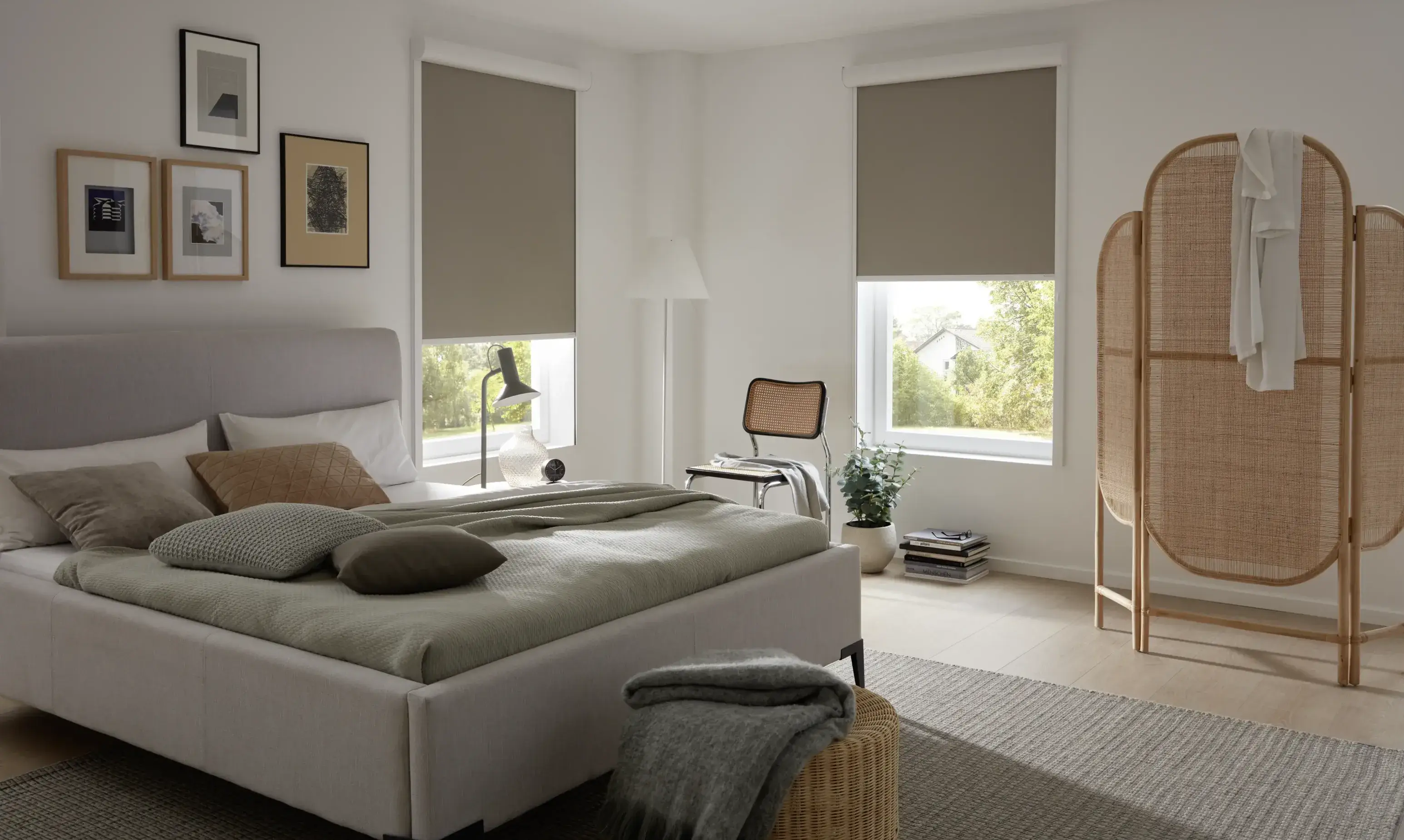 Frau im Schlafzimmer unter zwei NewShades-Dachfensterrollos.