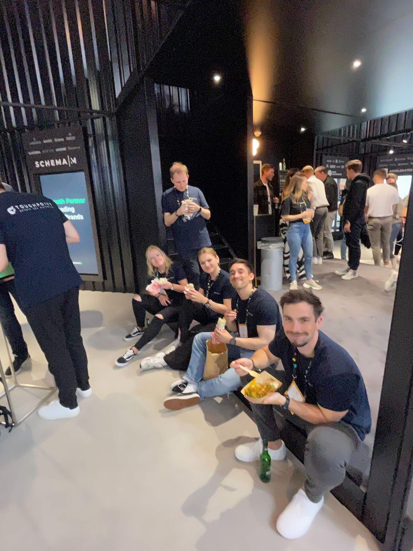 Kolleginnen und Kollegen sitzen nach dem Event-Tag zusammen in der Lounge.